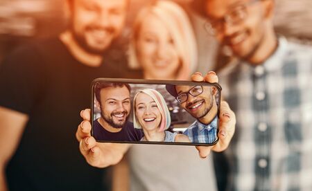 Diverse friends taking selfie together