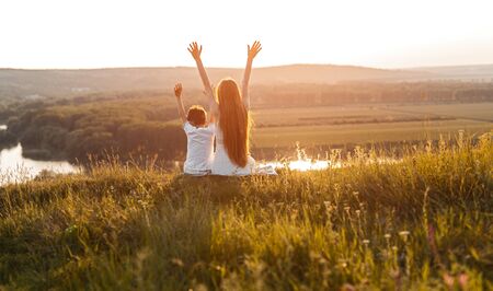 Anonymous brother and sister enjoying sunset in countrysideの写真素材