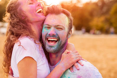 Happy couple having fun on beach during festivalの写真素材