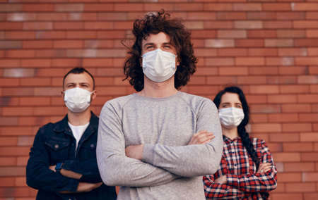 Confident man in mask with friendsの写真素材