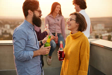 Happy couple talking during party on rooftop