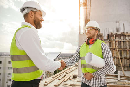 Positive construction workers shaking hands