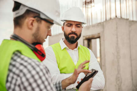 Construction workers using smartphone during work