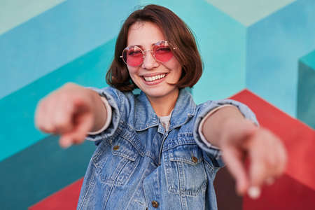 Cheerful young woman pointing at cameraの写真素材