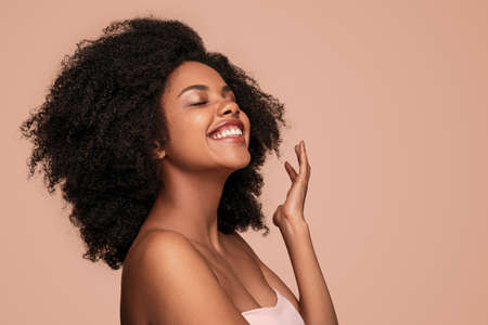 Delighted black woman enjoying skin cleannessの写真素材