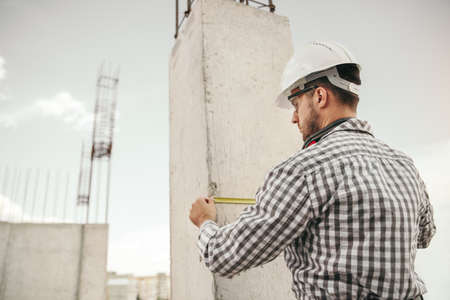 Male building measuring concrete column