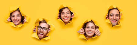 Cheerful young people looking out of ripped paper