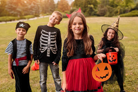Adorable kids in carnival costumes playing on nature backgroundの写真素材