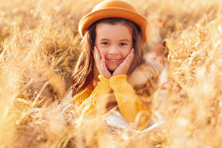 Happy girl in hat in yellow fieldの写真素材
