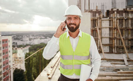 Bearded architect speaking on smartphone