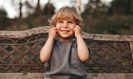 Cute child making face on benchの写真素材