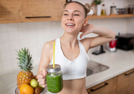 Happy slim woman with green smoothieの写真素材