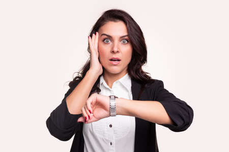 Stressful businesswoman checking time on wristwatchの写真素材