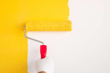 Unrecognizable worker painting wall with roller
