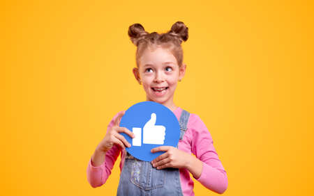 Cheerful little girl with thumb up icon