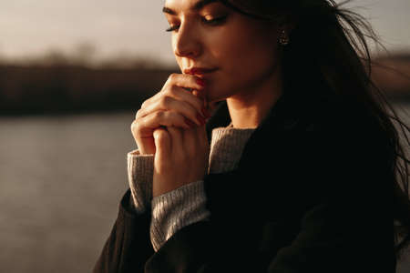 Quiet woman dreaming on lake shoreの写真素材