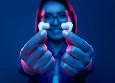 Happy woman showing modern earphonesの写真素材