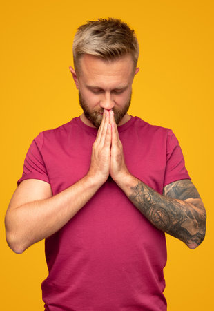 Adult man meditating and praying with hands togetherの写真素材