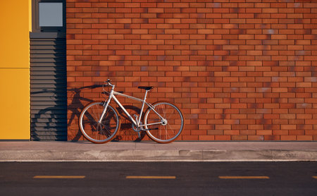 Stylish urban bicycle on sidewalk with brick wallの写真素材