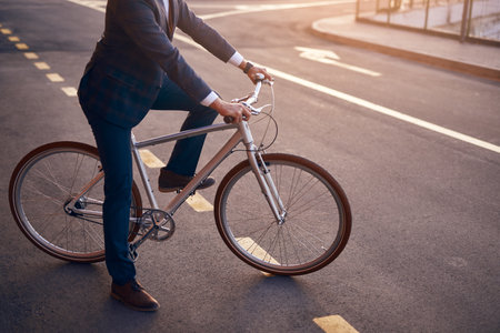 Commuter in formal outfit riding bike on streetの写真素材