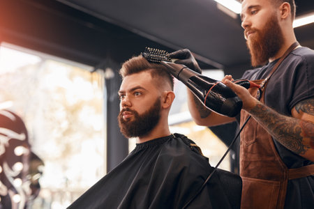 Male barber drying hair of hipsterの写真素材