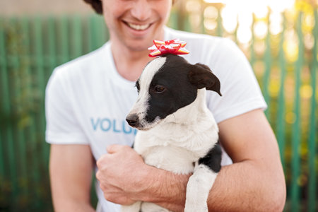 Crop happy man holding dog with bow