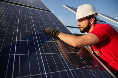 Bearded engineer touching solar panel