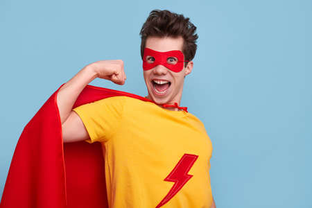 Excited male superhero showing muscleの写真素材