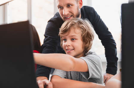 Schoolkid and teacher discussing study project on laptop