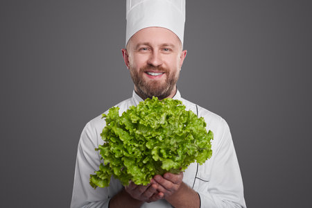 Cheerful male chef with fresh lettuceの写真素材