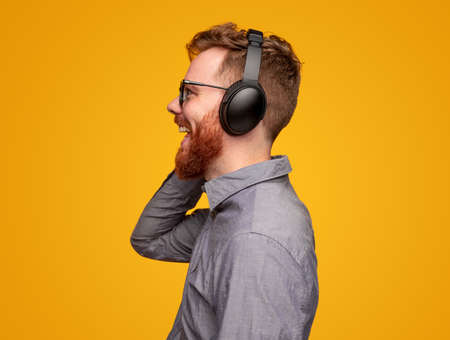 Happy bearded man in headphones enjoying music