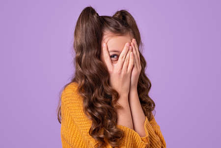 Shy girl covering face with hands
