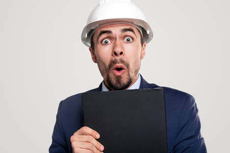 Shocked contractor with clipboard looking at camera