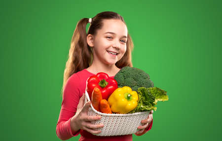 Happy kid with basket of fresh vegetablesの写真素材