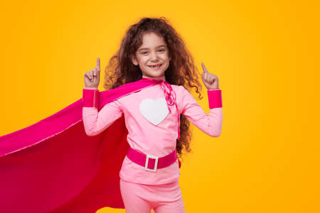 Cheerful superhero kid girl in pink costumeの写真素材