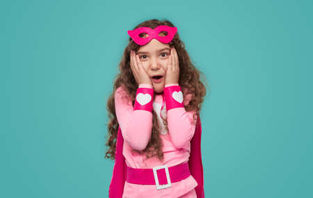 Shocked little superhero looking at cameraの写真素材