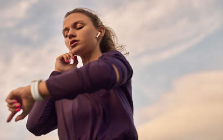 Female runner checking fitness tracker during trainingの写真素材