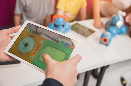 Teacher with kids creating robots in schoolの写真素材