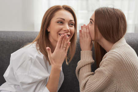 Happy mother and daughter sharing secretsの写真素材