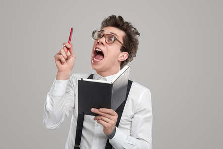 Nerd male writer having idea on gray backgroundの写真素材