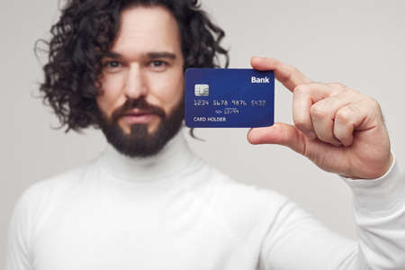 Bearded man showing bank cardの写真素材