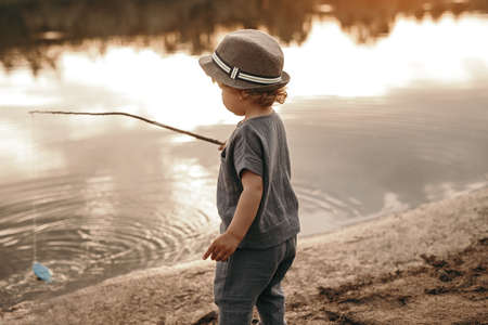 Little kid with fishing rod at lakeの写真素材
