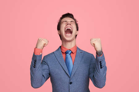 Excited young businessman celebrating successの写真素材