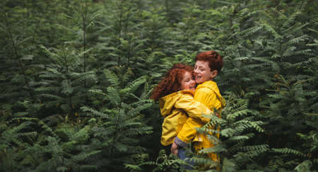 Happy siblings hugging in forestの写真素材