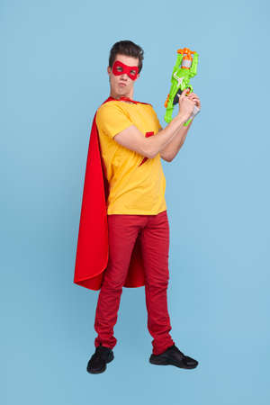 Funny superhero with toy gunの写真素材