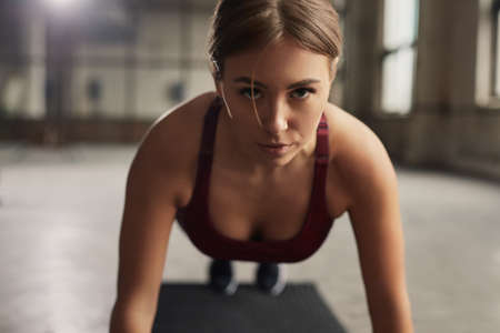 Confident sportswoman doing plank exerciseの写真素材