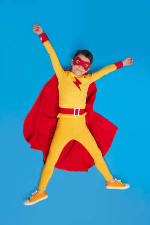 Superhero child in bright costume in studioの写真素材