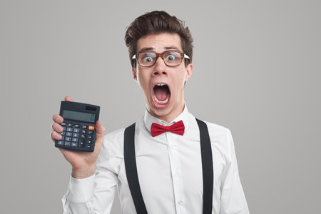 Furious businessman showing calculator with 0 numberの写真素材
