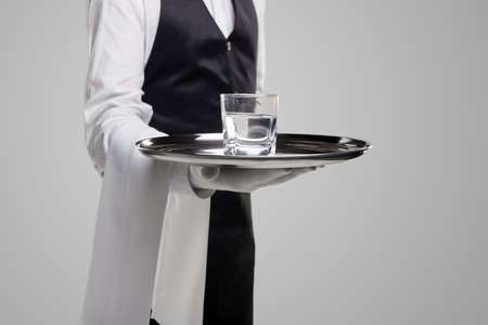 Crop waiter with glass of water on trayの写真素材