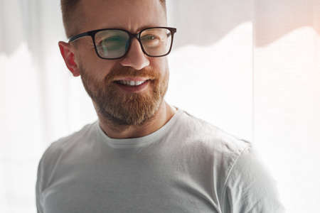 Smiling bearded man at home
